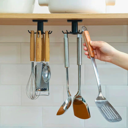 Kitchen utensils such as spatulas and whisks hanging from a black adhesive hook under a shelf